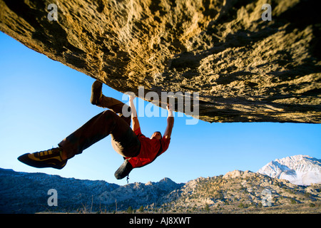 Man bouldering on an overhang Stock Photo