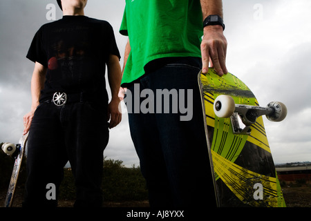 Two skateboarders shot low angle on mid section. Stock Photo