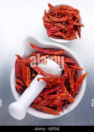 WHOLE RED DRIED CHILLIES IN PESTLE AND MORTAR Stock Photo