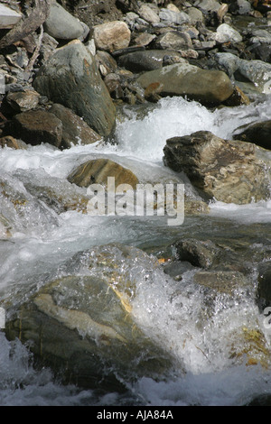 Rocks in fast flowing stream with water rushing over them Stock Photo