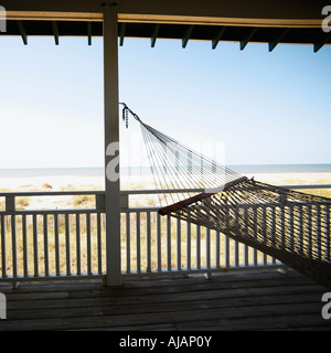 View of beach from porch with railing and hammock at Bald Head Island North Carolina Stock Photo