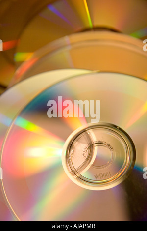 Stack of shiny compact discs on a plastic spindle under soft blue ...