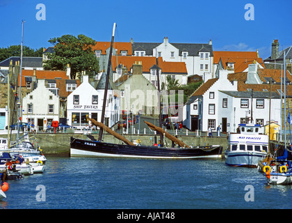 Fifie type fishing vessel Reaper tied up in Anstruther Harbour with the Scottish Fisheries Museum in the background Stock Photo