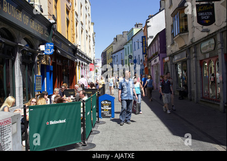 pedestrians and drinkers enjoying a sunday afternoon drink in the bunch of grapes pub high street galway Stock Photo