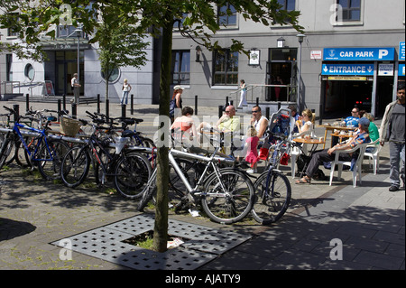 familes enjoying a drink and lunch on quay street next to a bike rack Galway city county Galway Republic of Ireland Stock Photo