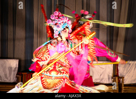 Talented and beautiful actress of the Chengdu Opera dressed in traditional clothing performing on the stage. Stock Photo