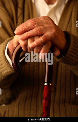 Old man with hands leaning on walking stick Stock Photo
