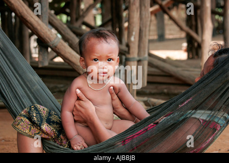 Mother and child in a hammock at the village of Kompong Phhluk, Tonle Sap, Nr Siem Reap, Cambodia. Stock Photo