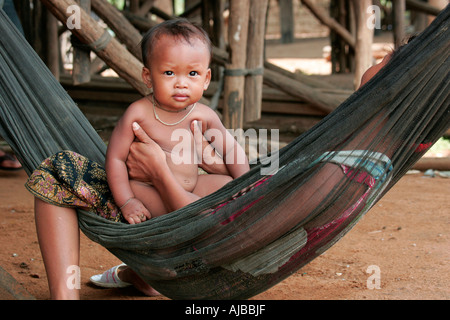 Mother and child in a hammock at the village of Kompong Phhluk, Tonle Sap, Nr Siem Reap, Cambodia. Stock Photo