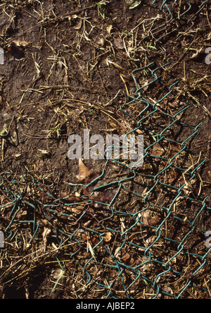 detail of broken fence on muddy floor ground in field Stock Photo