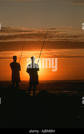 Two Silhouetted Fishermen Fishing at Sunrise Stock Photo