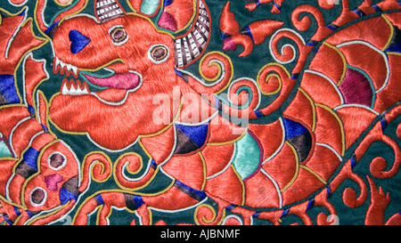 Ornately embroidered Tibetan garment depicting a dragon in red silk Tibet Stock Photo