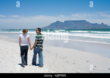 Couple Walking Hand in Hand on the Beachfront Stock Photo