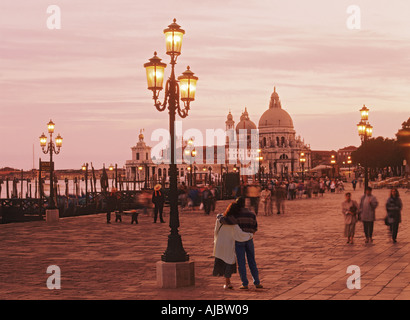 Couple embracing on waterfront near Piazza San Marco or St. Marks Square at dusk in Venice Italy Stock Photo