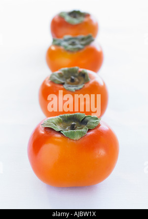 Four Ripe Orange Persimmons in a Row with White Background Stock Photo