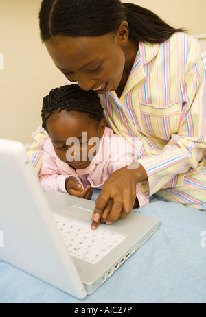 African Woman with her Daughter Using a Laptop Computer Stock Photo