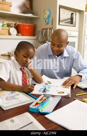 African Man Helping his Son with his Homework Stock Photo