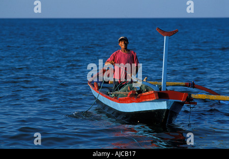 Young Balinese fisherman in his prahu coming ashore Pemuteran a fishing community on Bali s N coast Stock Photo