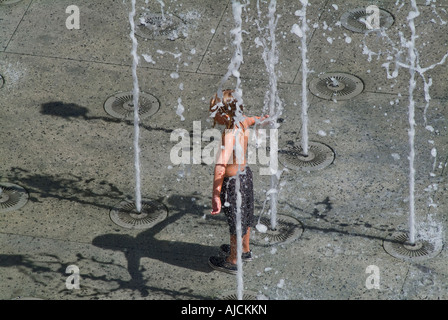 Small child playing in water fountain Stock Photo