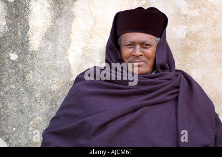 An Ethiopian Priest sits quietly in the sparce courtyard of the Ethiopian Church in Jerusalem's Old City. Stock Photo