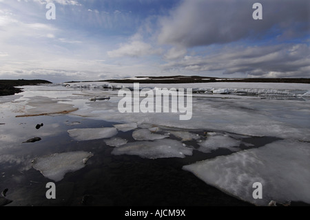 Spring melt in the Miohusaa river above the town of Egilstadir with a distant view of the Fjardarheidi mountains east Iceland Stock Photo