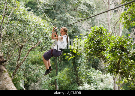 Woman on a zip line at The Gibbon Experience near Huay Xai on the Mekong river near the Laos Thai border Stock Photo