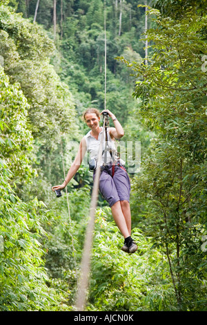 Woman on a zip line at The Gibbon Experience near Huay Xai on the Mekong river near the Laos Thai border Stock Photo