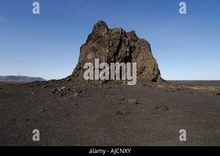 Large basalt crag or pinnacle on a cinder plain to the east of the town of Vik southern Iceland Stock Photo