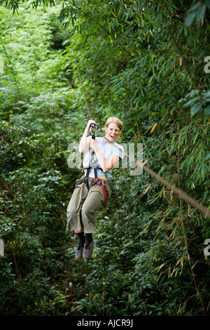 Woman on a zip line at The Gibbon Experience near Huay Xai on the Mekong river near the Laos Thai border Stock Photo