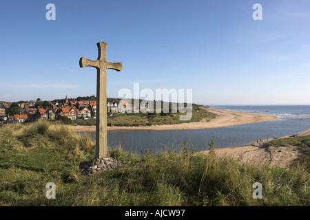 The coastal village of Alnmouth in Northumberland England as viewed from Church Hill with a carved Saxon cross in the foregroun Stock Photo