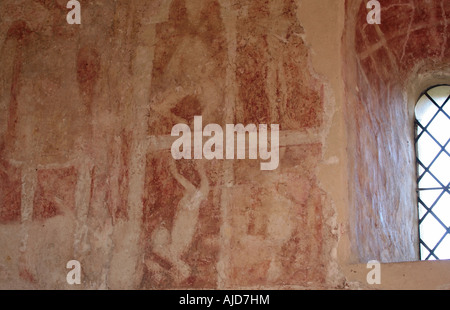 Early Christian medieval wall paintings depicting Pagan Idols Falling. St Botolphs Church, Hardham, West Sussex. UK Stock Photo