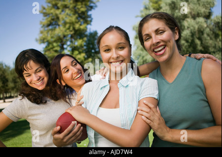 Four women playing football outdoors. Stock Photo