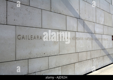 Wall outside the National Gallery of Ireland with 'National Gallery of Ireland' written chiseled on it in the Irish Language Stock Photo