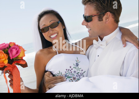 Groom carrying bride outdoors, (close-up) Stock Photo