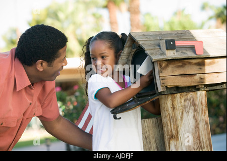 Father and Daughter checking mail at domestic Mailbox Stock Photo