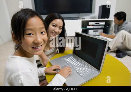 Family in Living Room Using Laptop and Home Theatre System, portrait Stock Photo