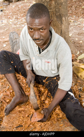 Craftsman makes traditional wooden mask Brikama craft market The Gambia Stock Photo