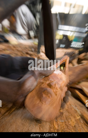 Craftsman makes traditional wooden mask Brikama craft market The Gambia Stock Photo