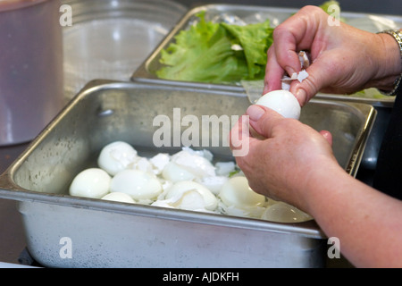 Kitchen staff remove shells off of hard boiled eggs to be used in fresh ...