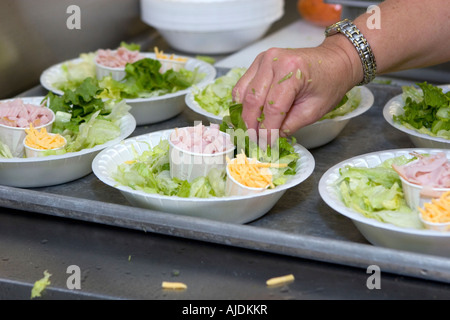 Kitchen staff prepares lunch salads daily in school kitchen Stock Photo