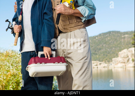 Father and son on fishing trip, (mid section) Stock Photo