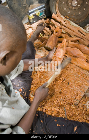 Craftsman makes traditional wooden mask Brikama craft market The Gambia Stock Photo