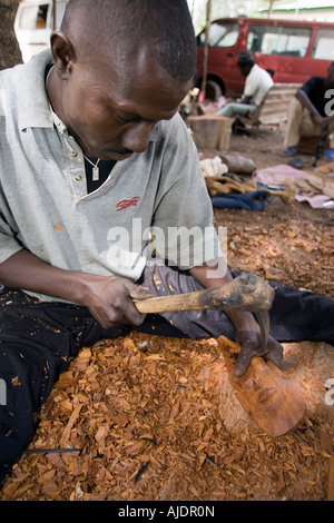 Craftsman makes traditional wooden mask Brikama craft market The Gambia Stock Photo