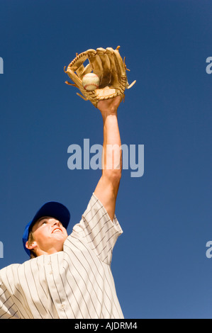 Baseball player catching ball in baseball glove, (low angle view) Stock Photo