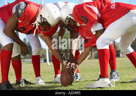 Football Players in Huddle around ball Stock Photo