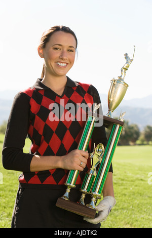 Female golfer holding trophy, (portrait Stock Photo - Alamy