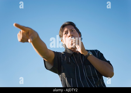 Soccer referee blowing whistle and pointing, portrait Stock Photo