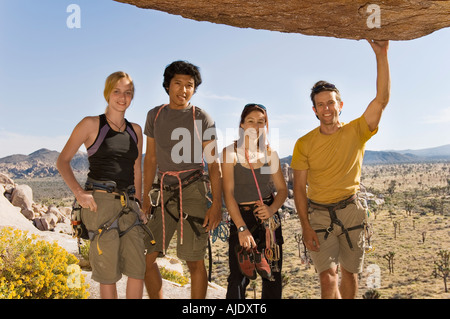Young Climbers standing Underneath Rock, (portrait) Stock Photo
