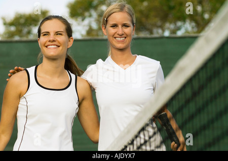 Tennis Players arms around Each Other over net After Match Stock Photo