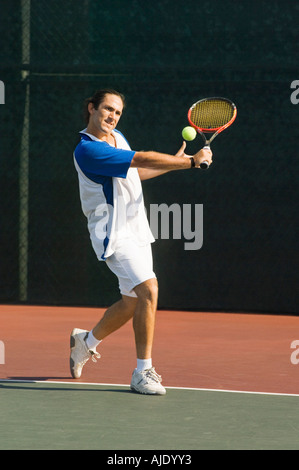 Tennis Player on court, preparing to return tennis ball with backhand Stock Photo